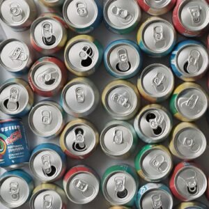 Top view of colorful aluminum cans ready for recycling, showing open tabs.